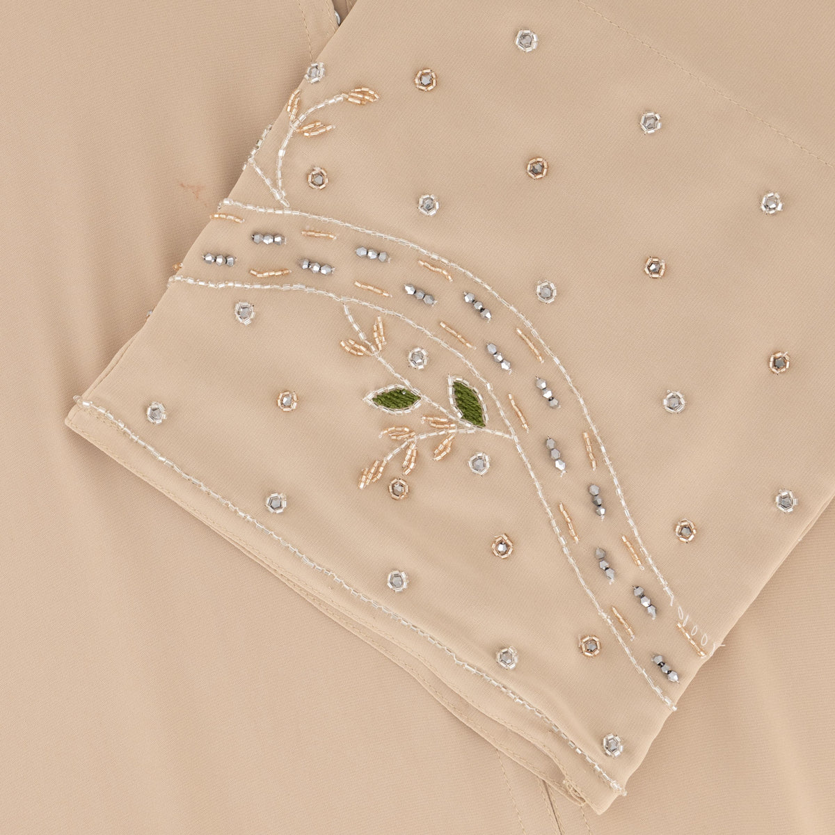Reema Abaya available in Black, Vanilla, and Chocolate Brown with golden and silver beaded sleeves in a floral and leafy design. Made from crepe fabric with popper buttons, available in sizes 50-60. Includes a matching hijab.